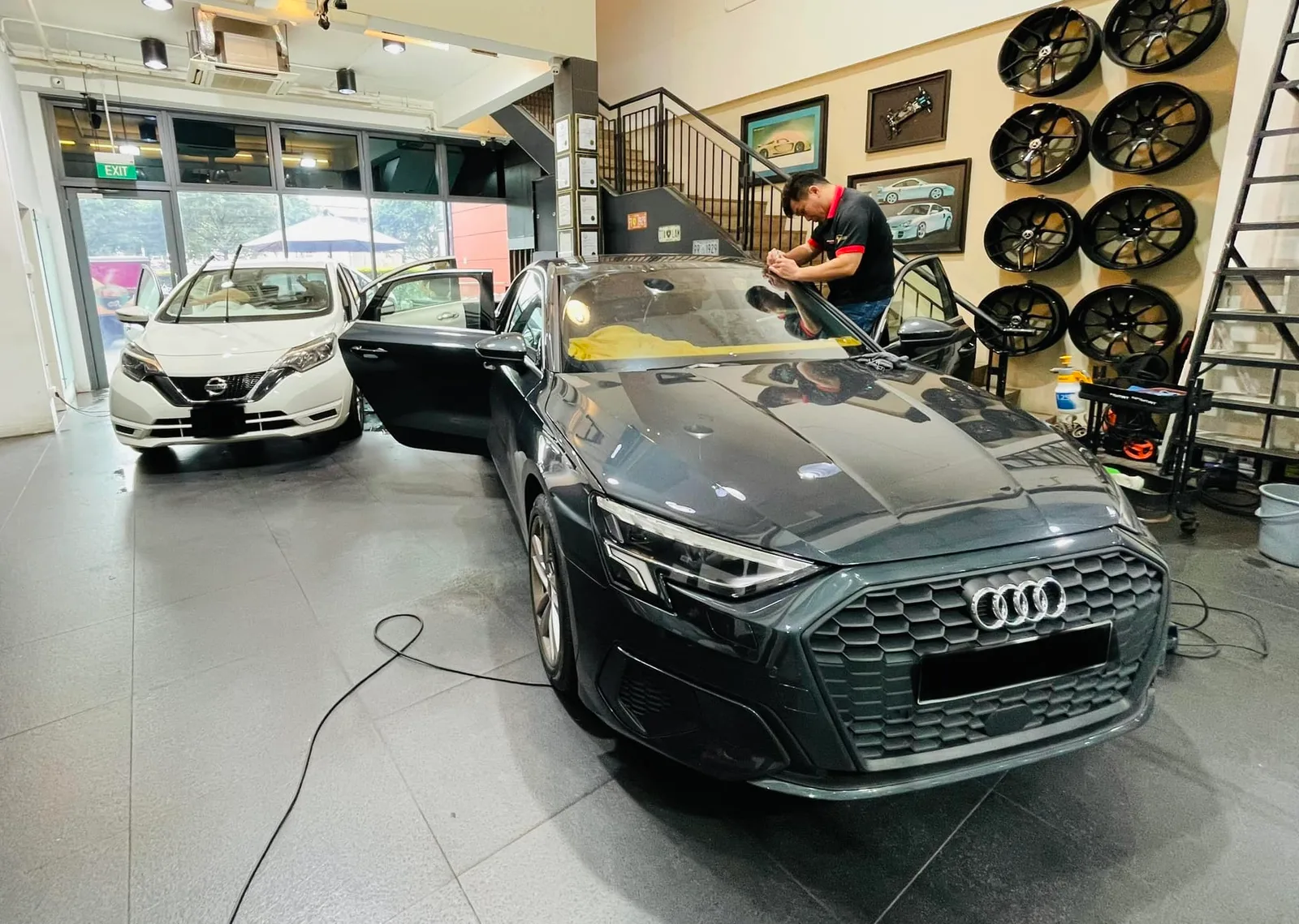 Black Audi sedan and white Nissan Note at Infratint Singapore during window tinting
