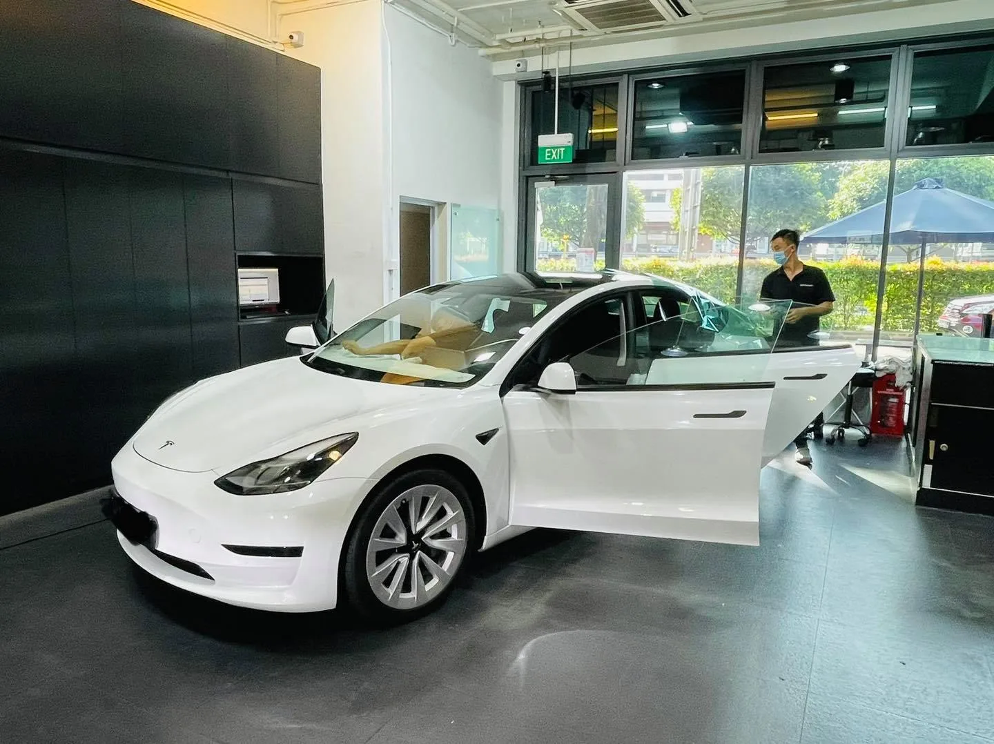White Tesla Model 3 front three-quarter view during window tinting at Infratint Singapore