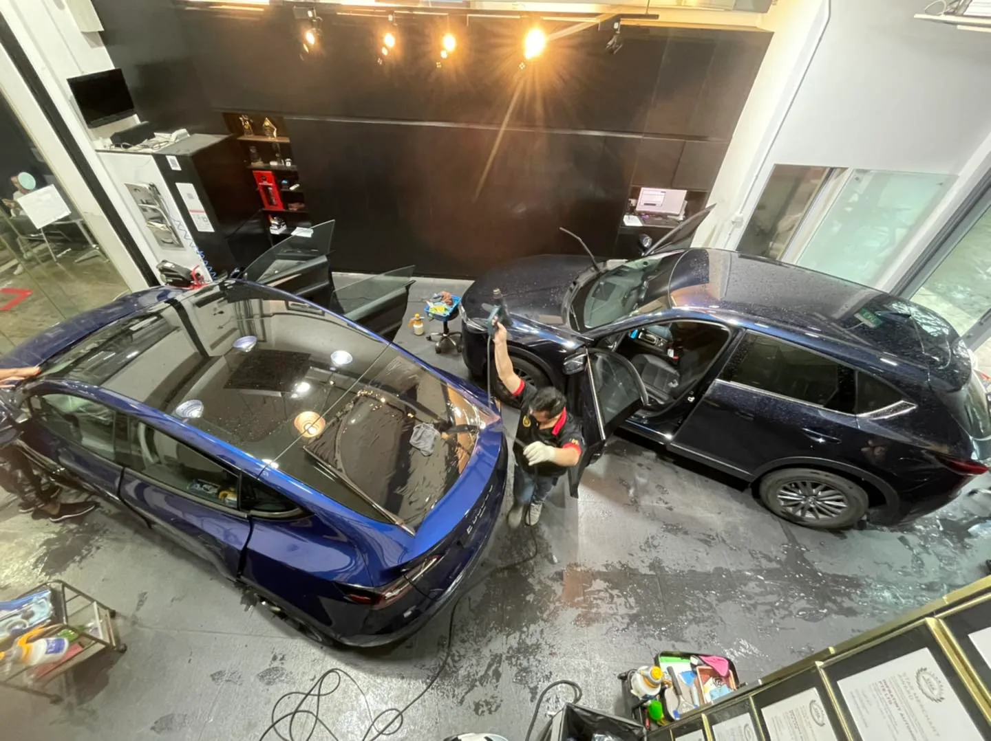Overhead view of a blue Tesla and dark Lexus SUV being tinted at Infratint Singapore