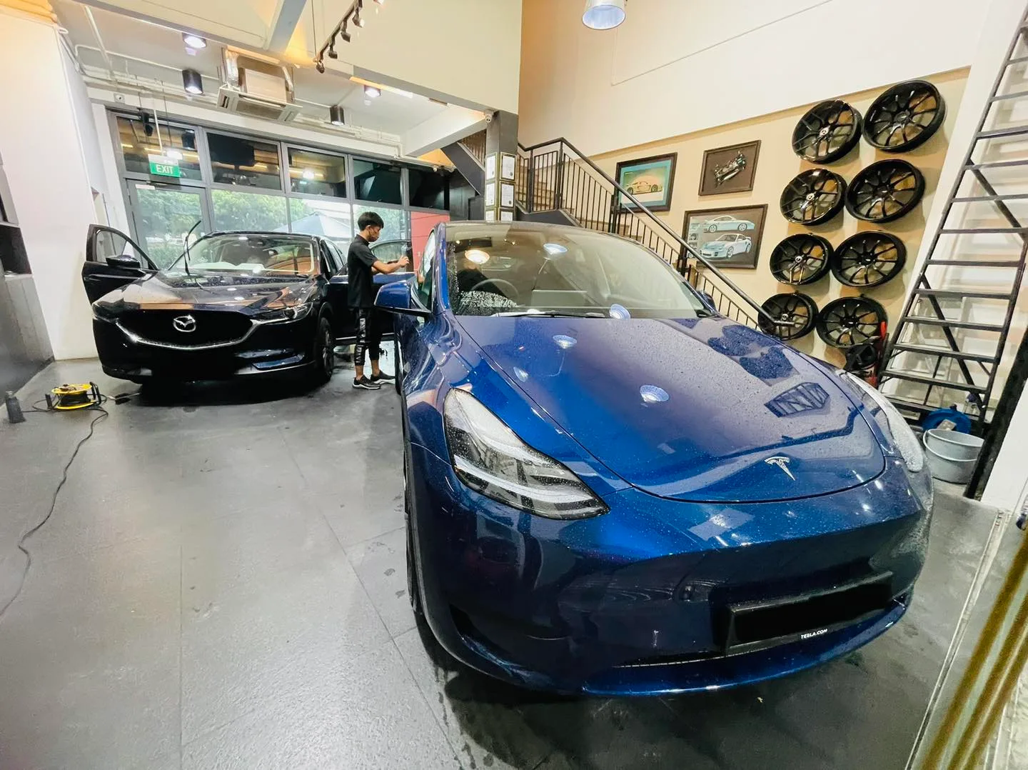 Blue Tesla Model 3 and dark Mazda CX-5 during window tinting at Infratint Singapore