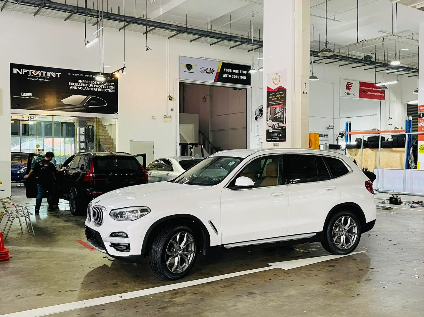 White BMW X3 front three-quarter inside the Infratint Singapore install bay