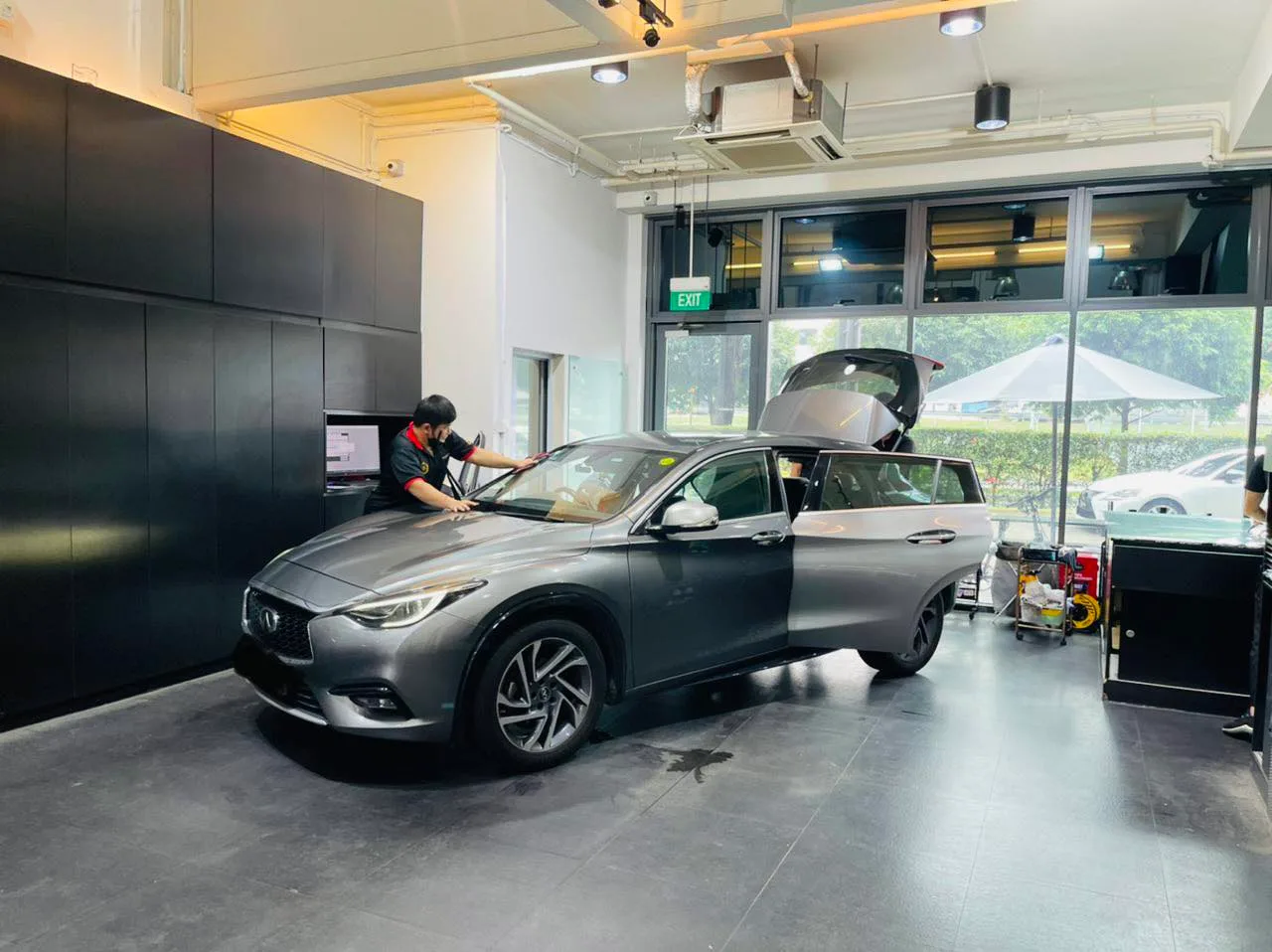 Grey Infiniti Q30 side view with boot open during window film install at Infratint Singapore