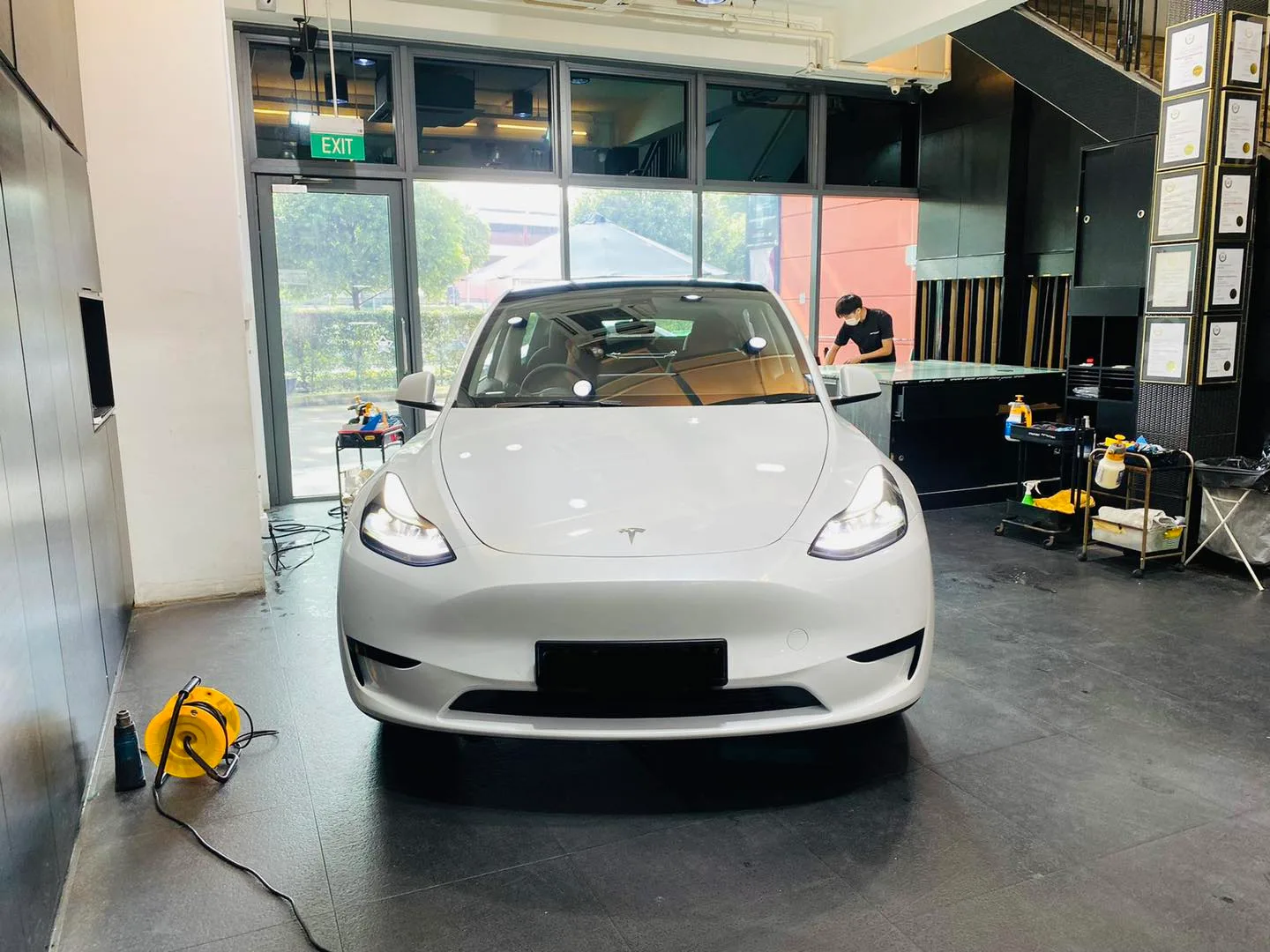 White Tesla Model Y front view during window tinting at Infratint Singapore