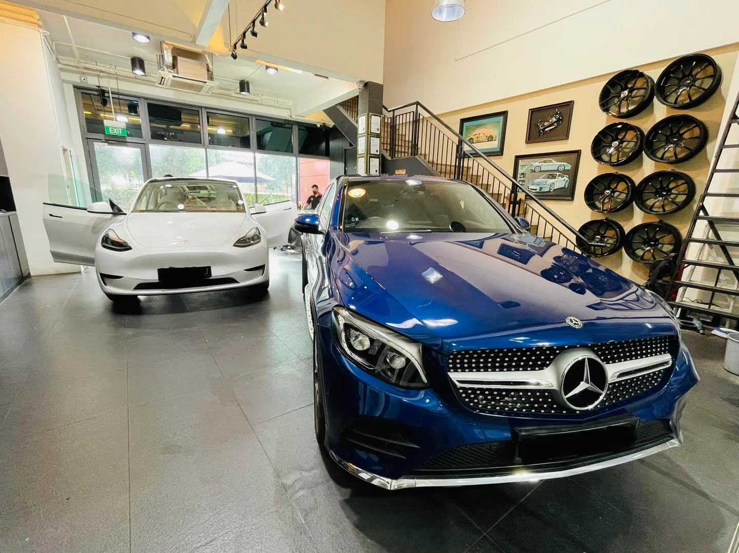 Blue Mercedes-Benz GLC and white Tesla inside the Infratint Singapore showroom