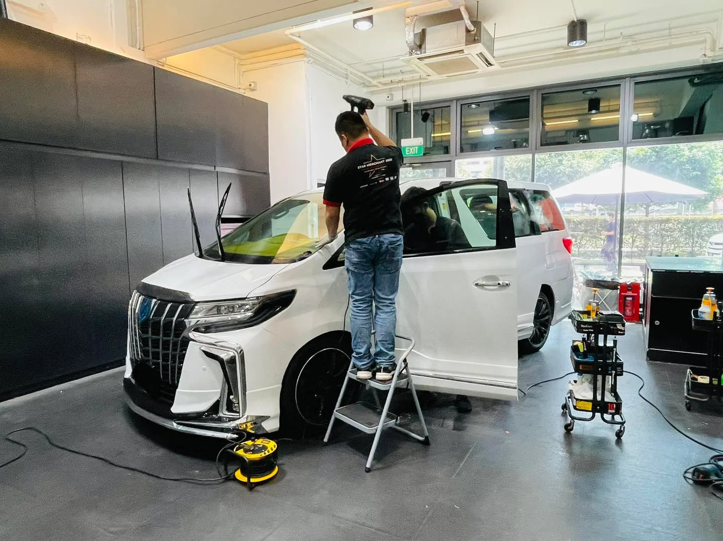 Installer applying window film to a white Toyota Alphard at Infratint Singapore