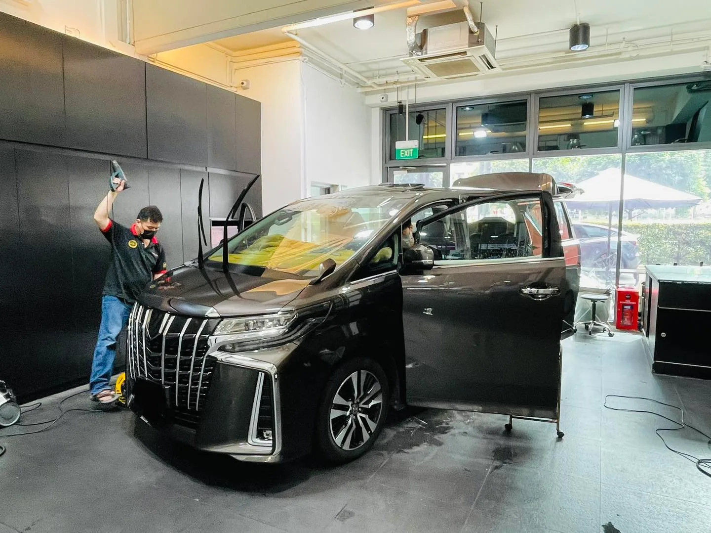 Dark Toyota Alphard front three-quarter with open door during tinting at Infratint Singapore