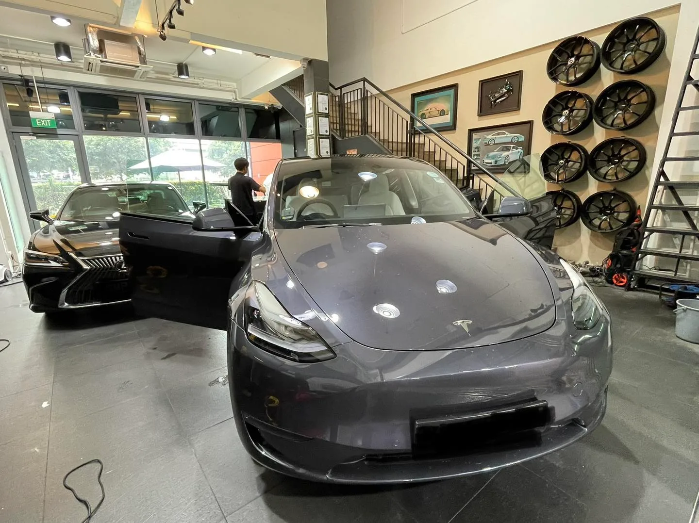Grey Tesla Model Y front three-quarter by the wheel display at Infratint Singapore