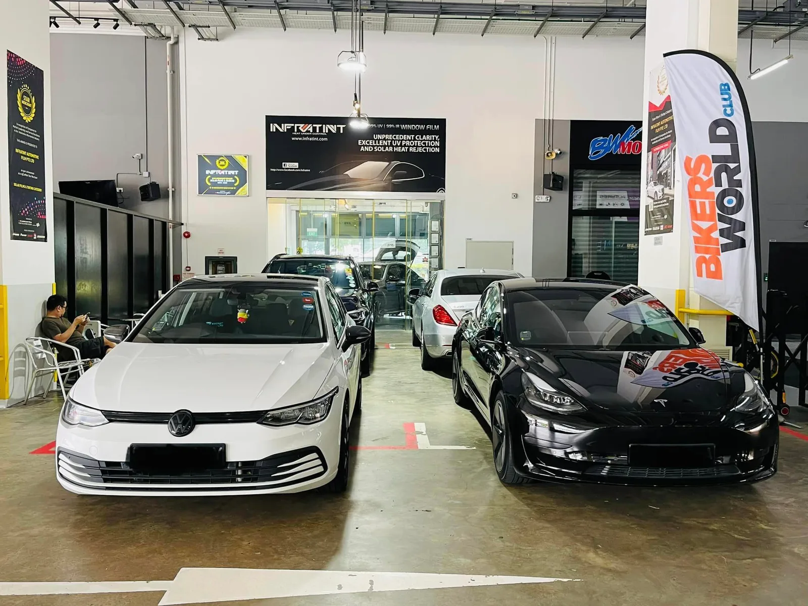 White Volkswagen Golf and black Tesla Model 3 at Infratint Singapore window tinting workshop