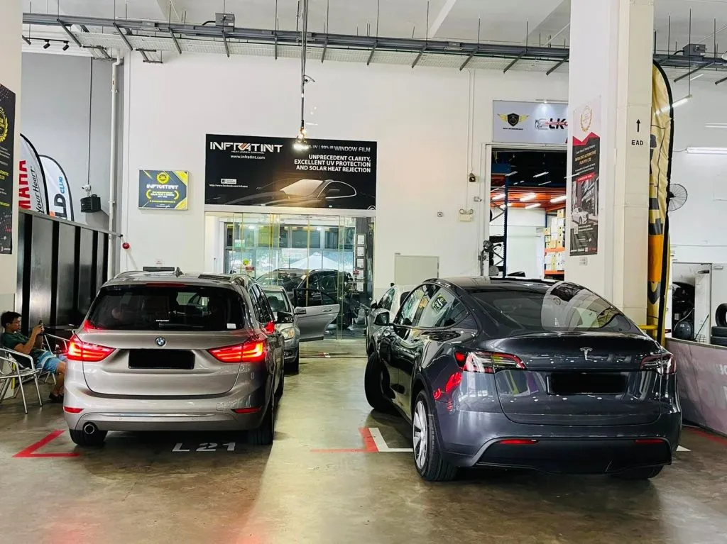 Silver BMW 2 Series and grey Tesla Model Y rear view in the Infratint install bay