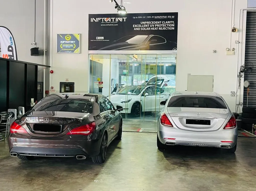 Mercedes-Benz CLA and S-Class at Infratint with a Tesla Model Y in the showroom behind