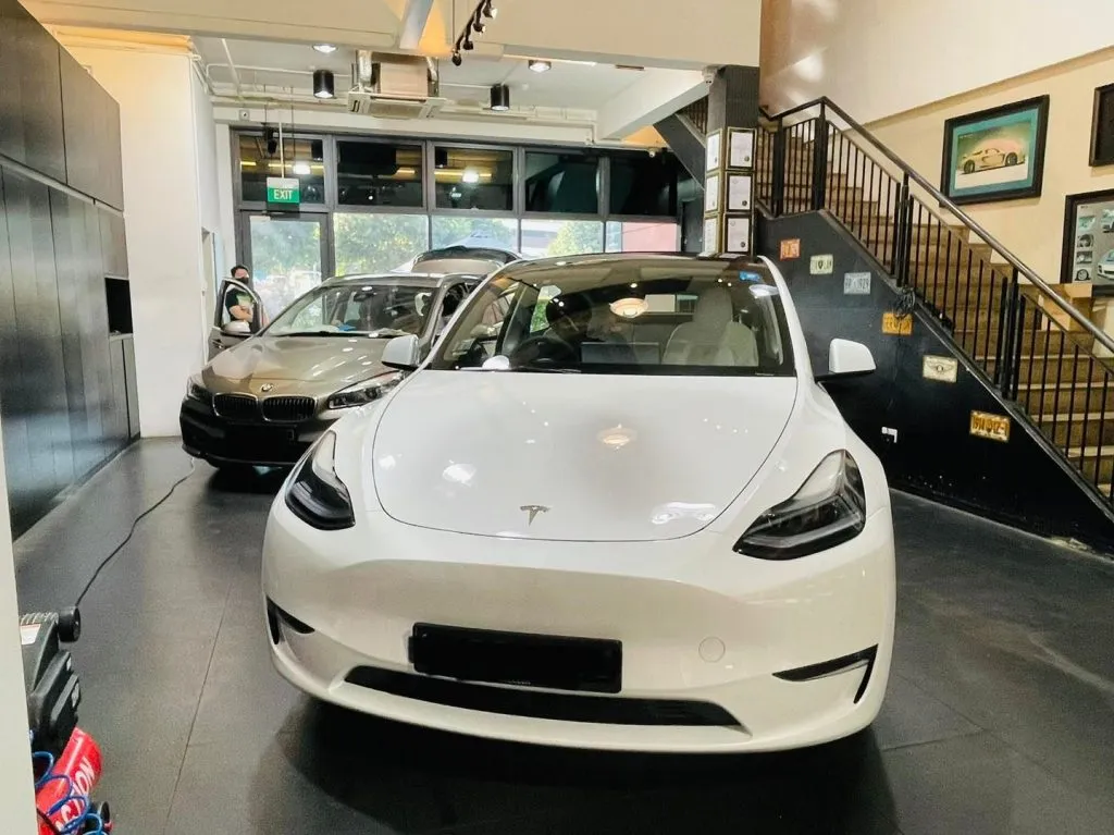 White Tesla Model Y and champagne BMW 2 Series at Infratint Singapore for window tinting