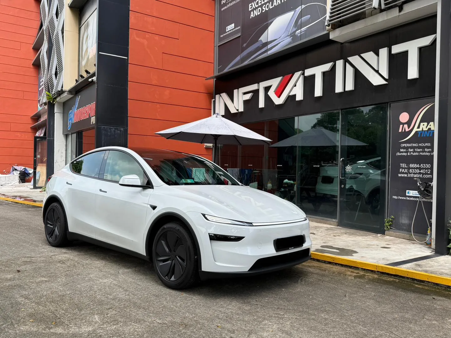 White Tesla Model Y Juniper front three-quarter view outside Infratint Singapore