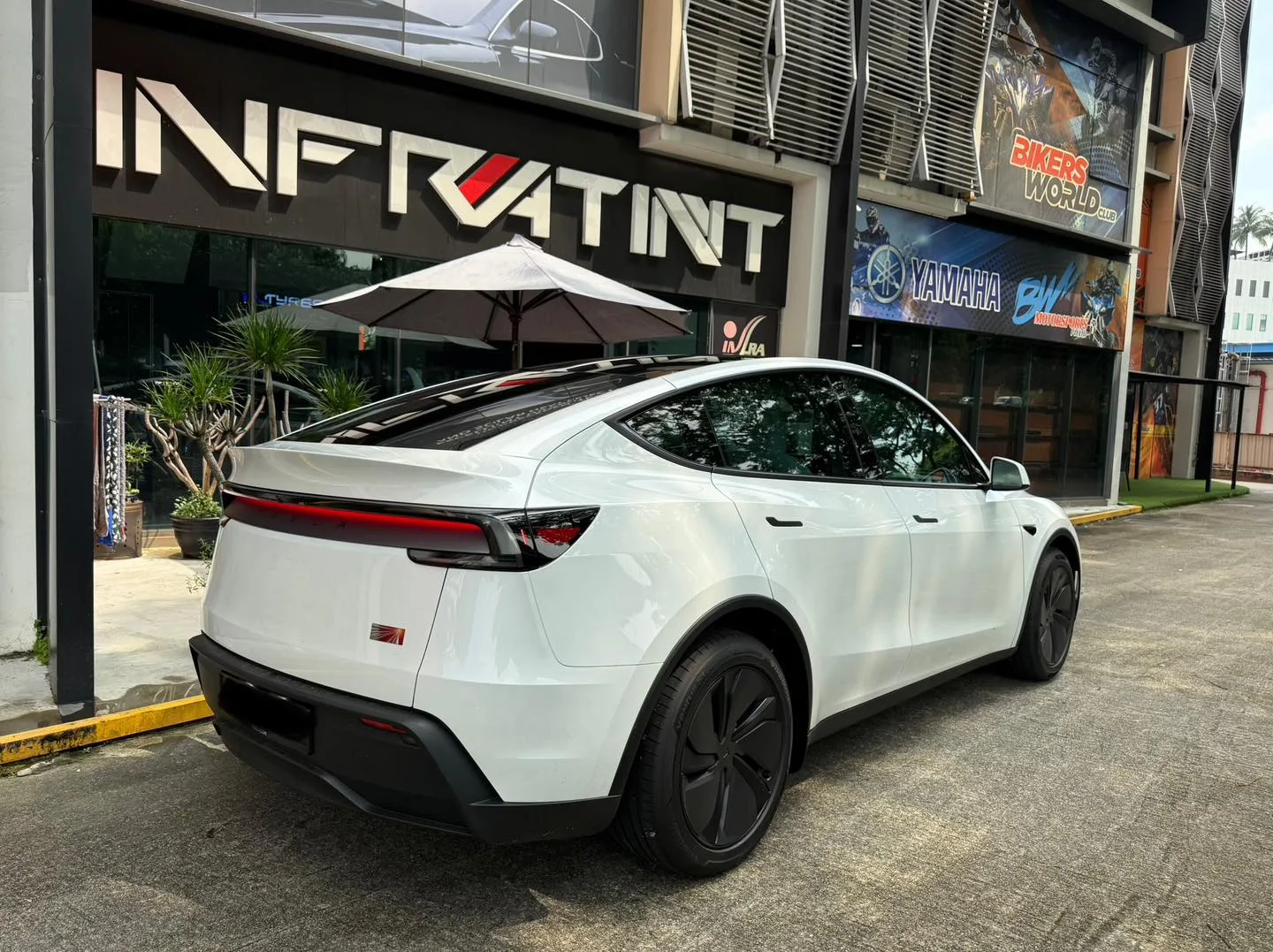 White Tesla Model Y Juniper rear three-quarter with tinted glass at Infratint Singapore