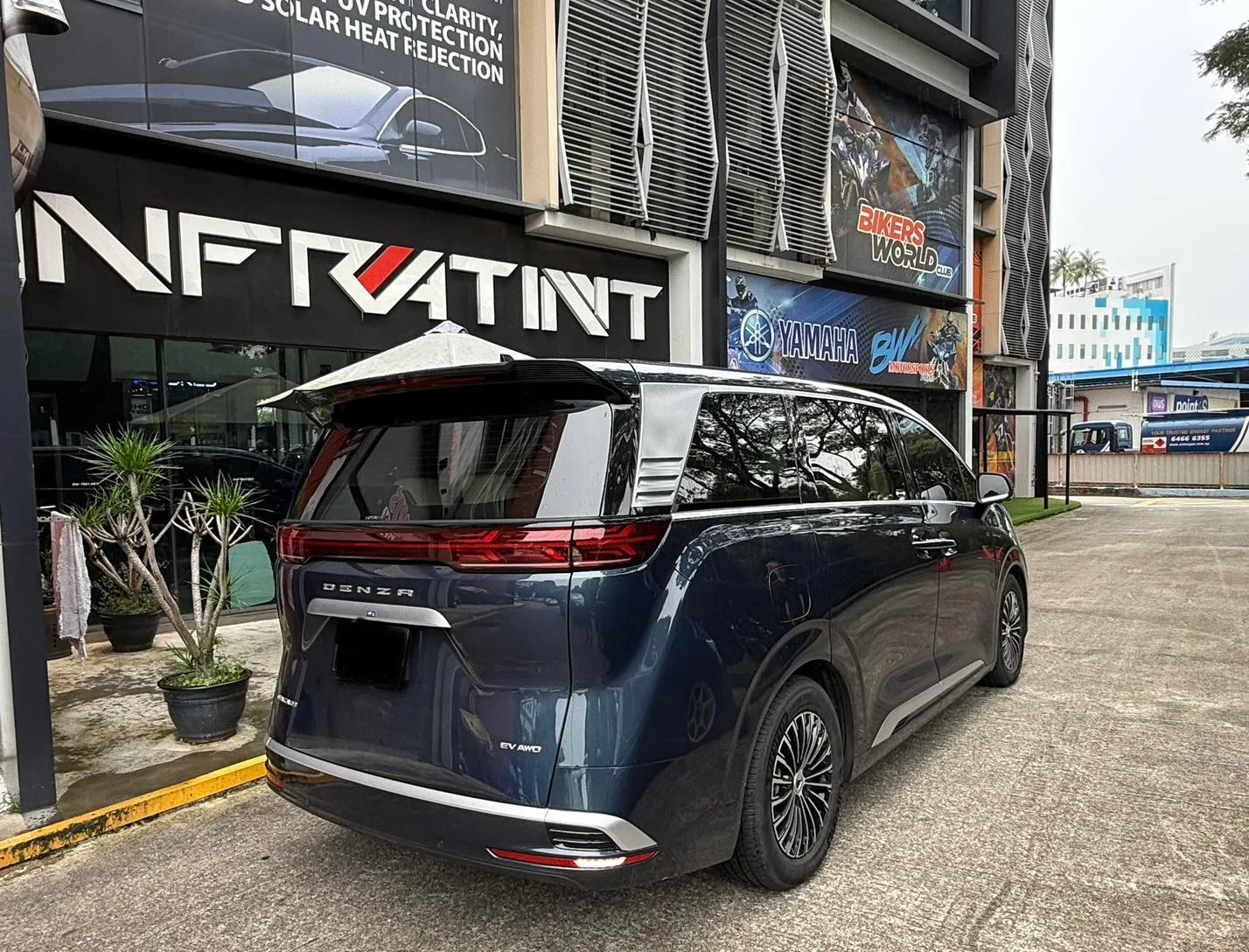 Dark blue Denza luxury MPV rear three-quarter view with tinted glass at Infratint Singapore