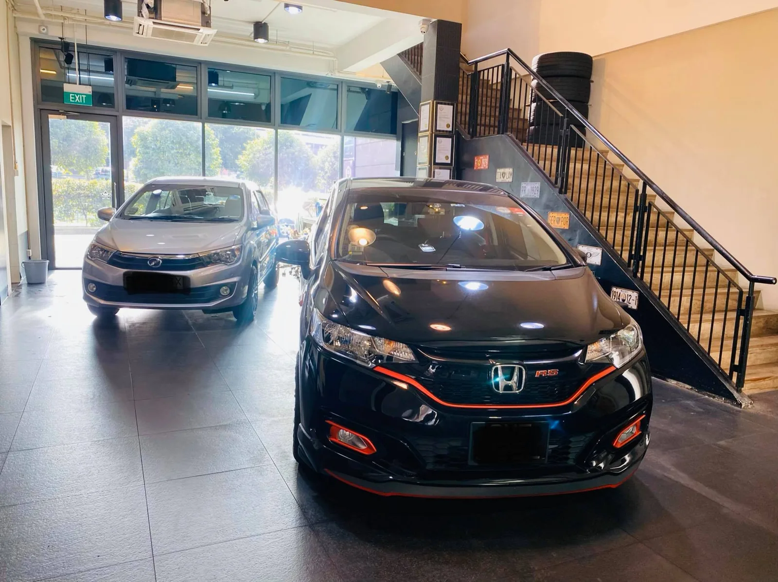 Black Honda Fit RS and a grey Perodua inside Infratint Singapore for window tinting
