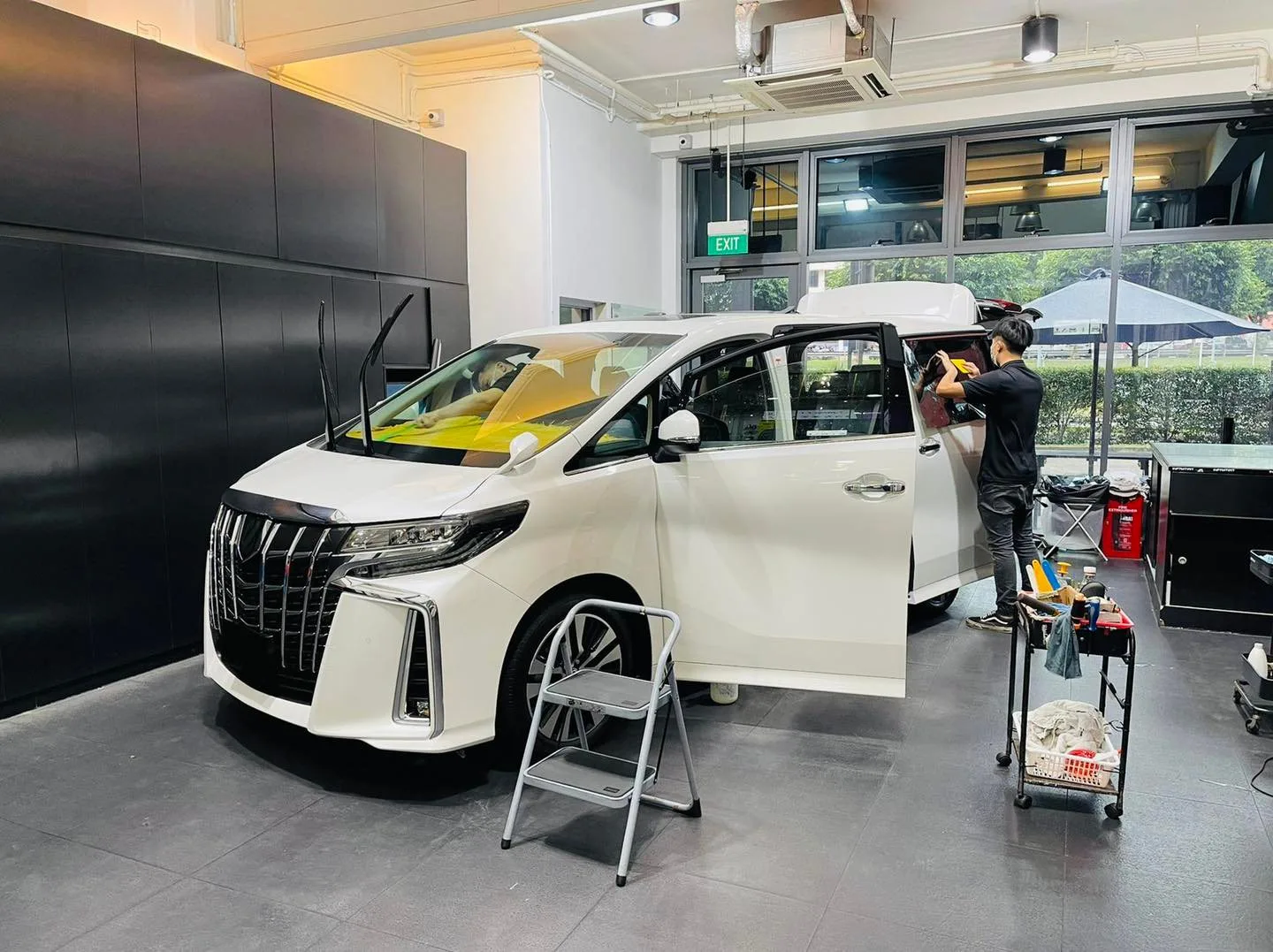 Side view of a white Toyota Alphard during tinting at Infratint Singapore