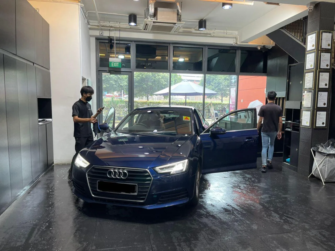 Dark blue Audi A4 with doors open during window tinting at Infratint Singapore