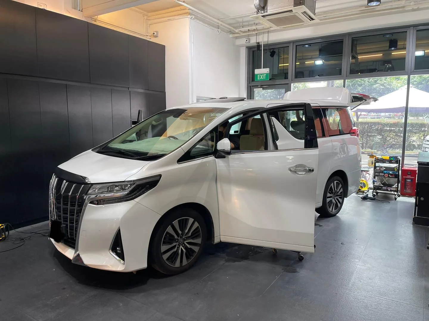 White Toyota Alphard with tailgate up during window film install at Infratint Singapore