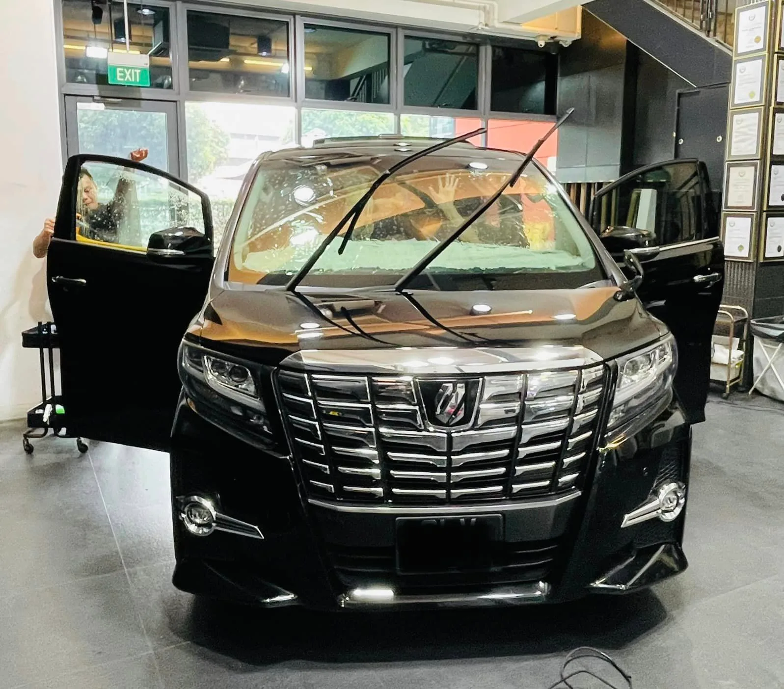 Black Toyota Alphard with door open during window tinting at Infratint Singapore
