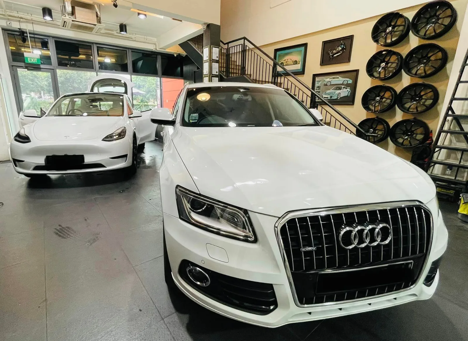 White Audi Q5 front view beside a white Tesla Model Y at Infratint Singapore