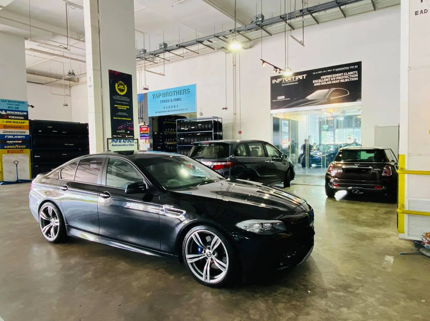 Black BMW 5 Series sedan in the workshop at Infratint Singapore
