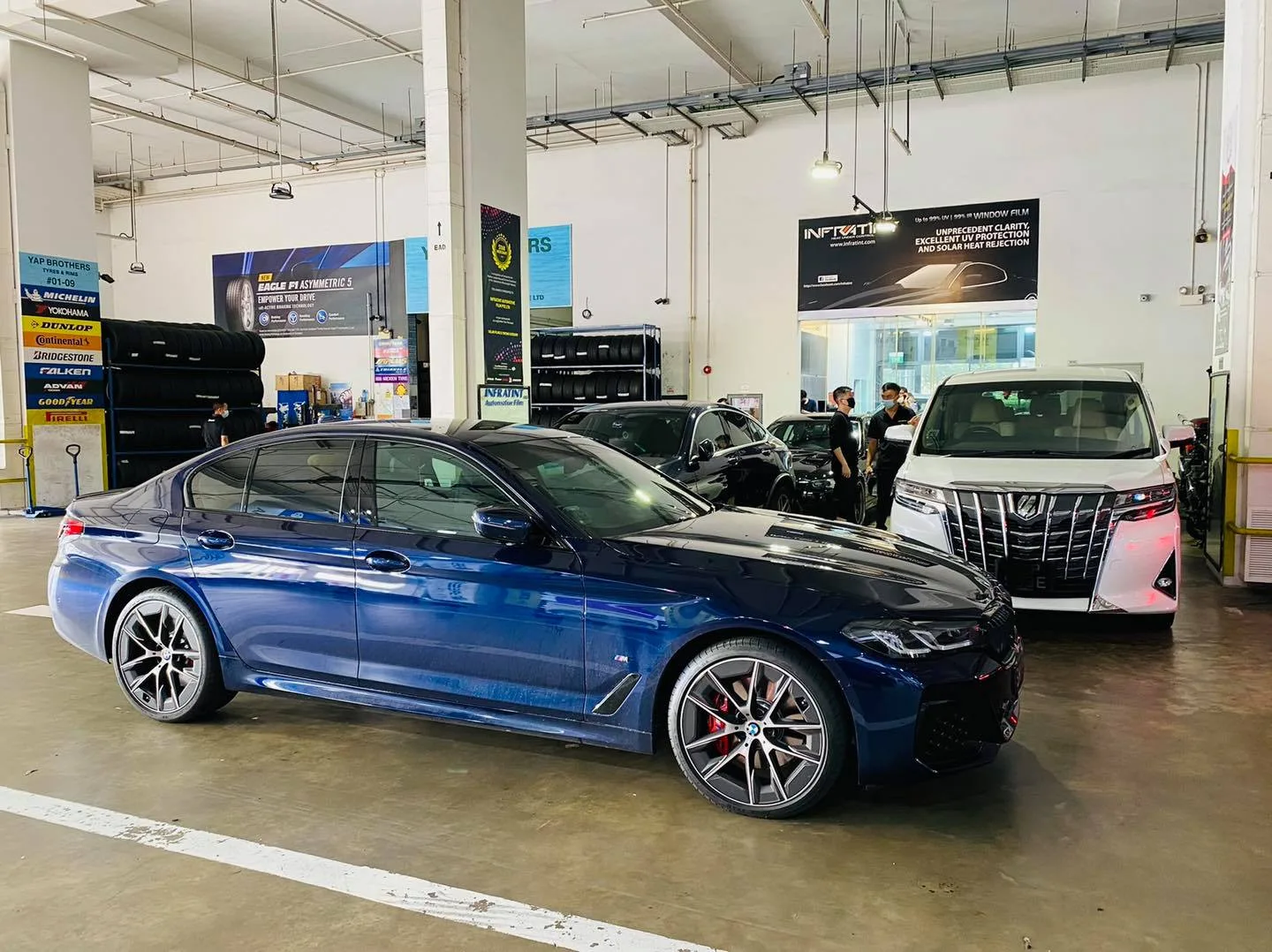 Blue BMW 5 Series sedan and Toyota Alphard at Infratint Singapore