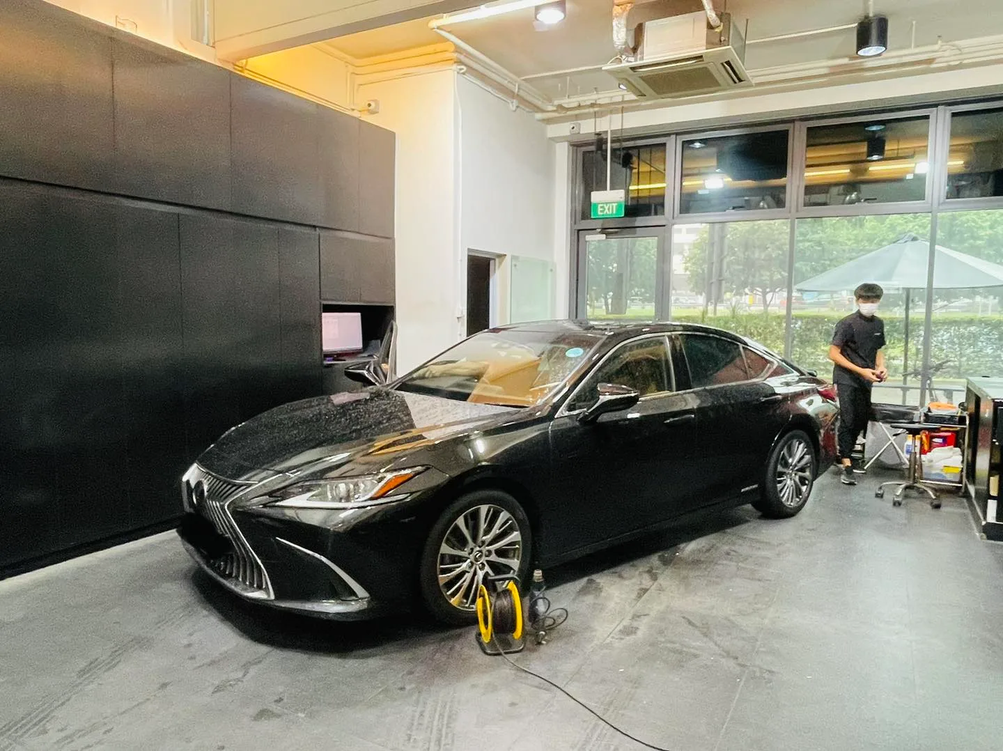 Black Lexus sedan on jack stands during window tinting at Infratint Singapore