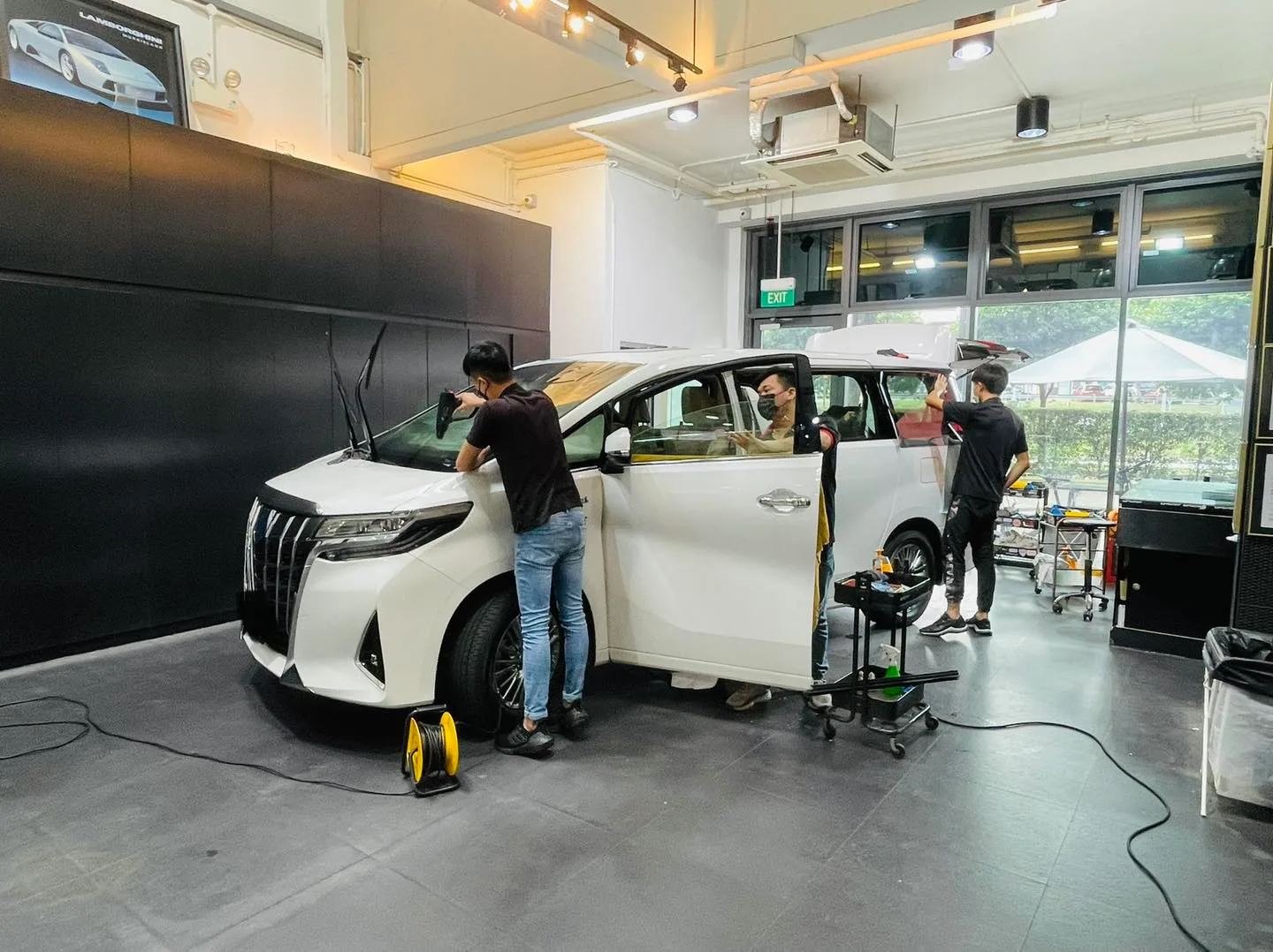 White Toyota Alphard with doors open during solar film install at Infratint Singapore