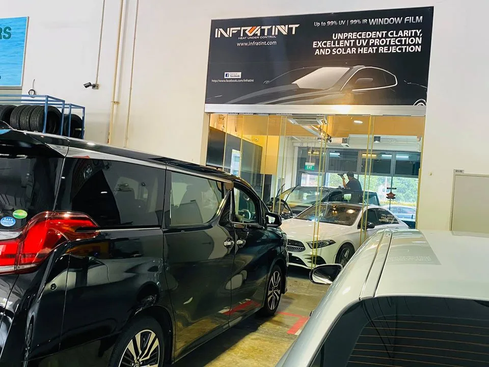 Black Toyota Alphard under the Infratint window film banner at Infratint Singapore