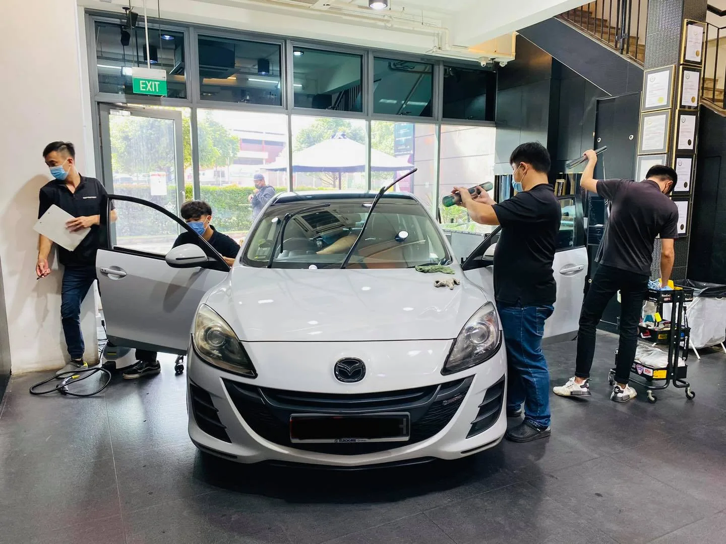 White Mazda 3 front view with doors open during tinting at Infratint Singapore
