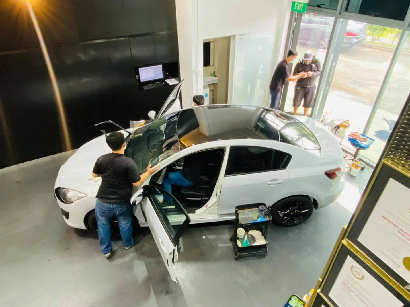 White Mazda 3 rear glass being tinted from an overhead view at Infratint Singapore