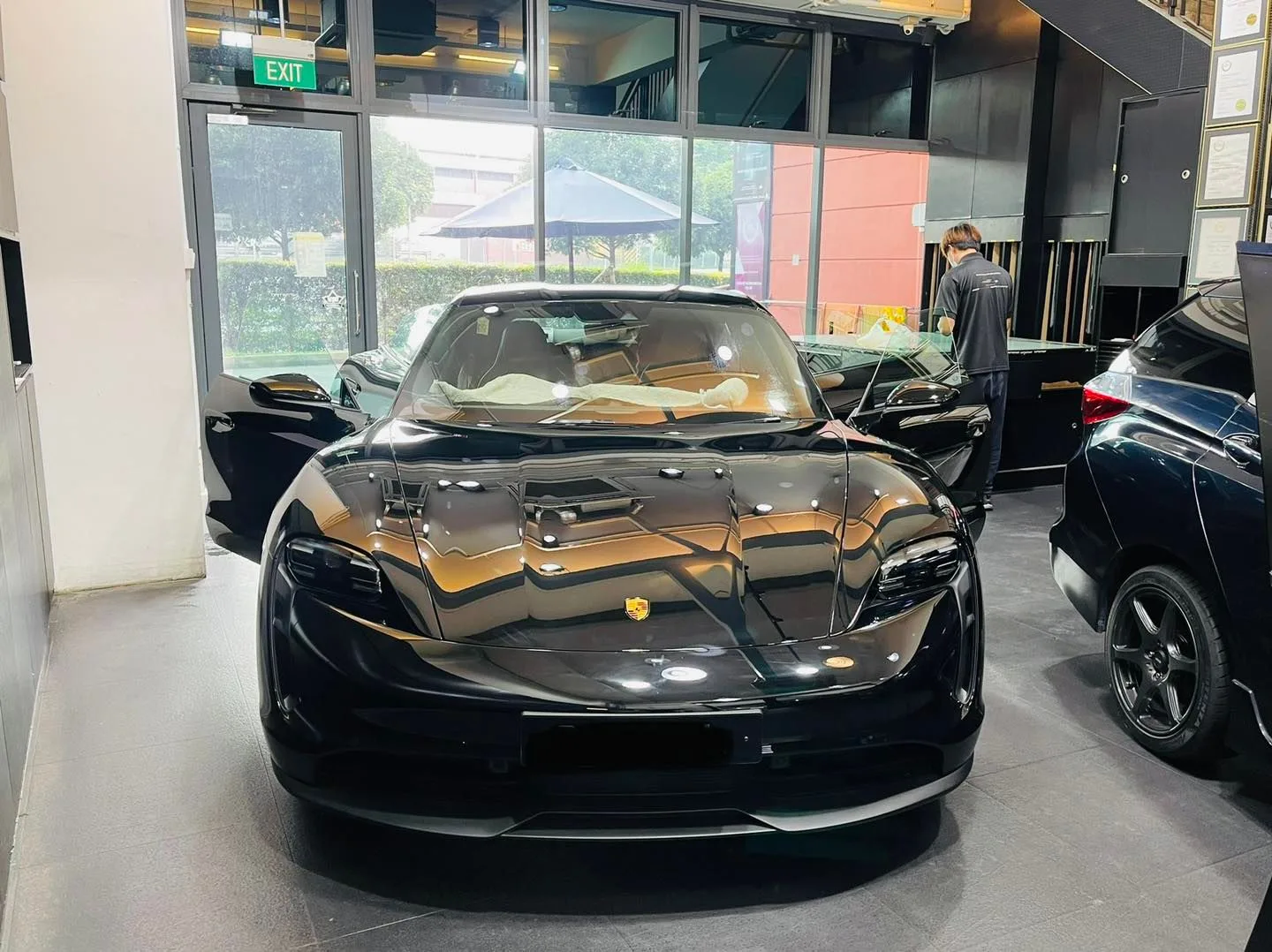 Black Porsche Taycan inside the Infratint Singapore showroom for window tinting