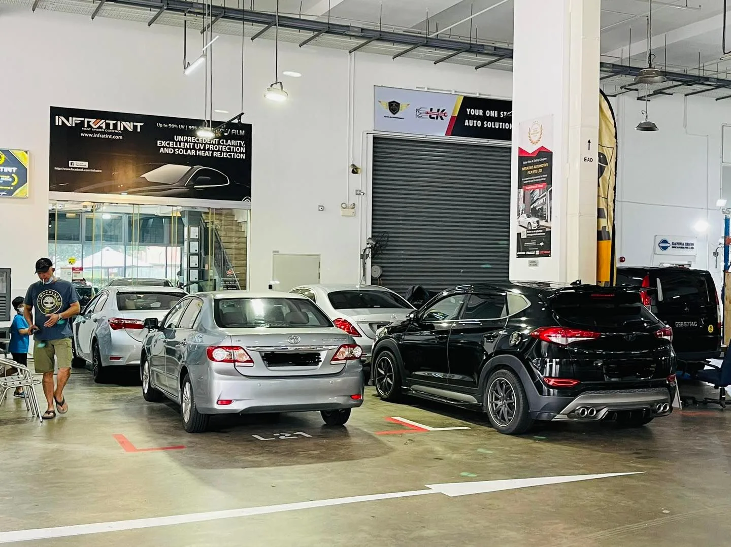 Silver Toyota Corolla Altis and a black SUV in the install bay at Infratint Singapore