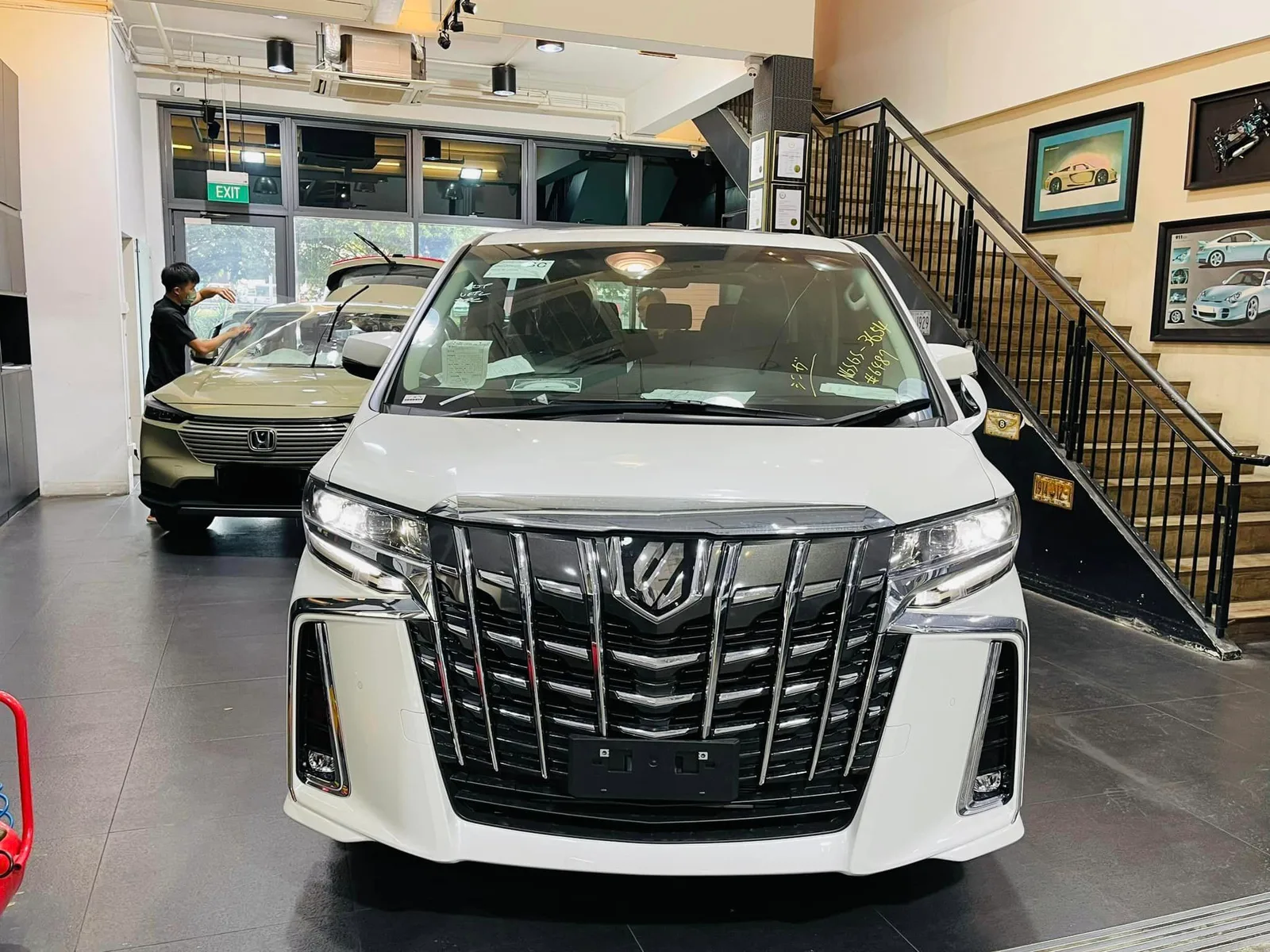 White Toyota Alphard front view at Infratint Singapore with a Honda HR-V behind