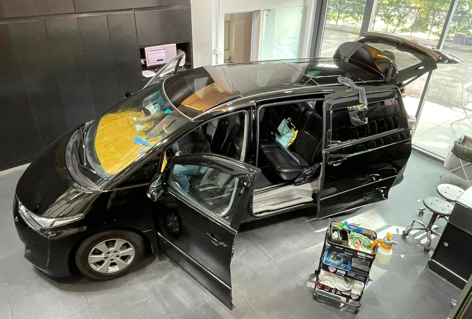 Overhead view of a black Toyota Estima during window film installation at Infratint Singapore