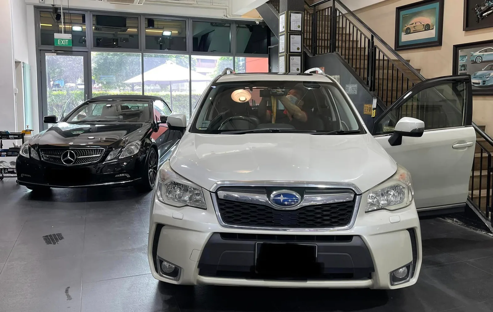 White Subaru Forester and black Mercedes-Benz coupe inside the Infratint Singapore showroom