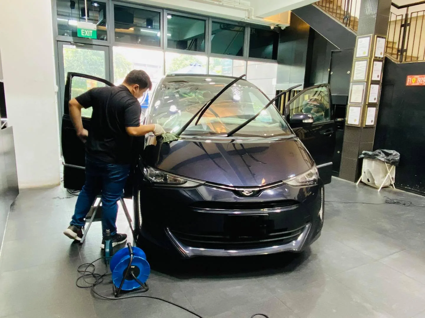 Dark Toyota Estima MPV front view during window tinting at Infratint Singapore