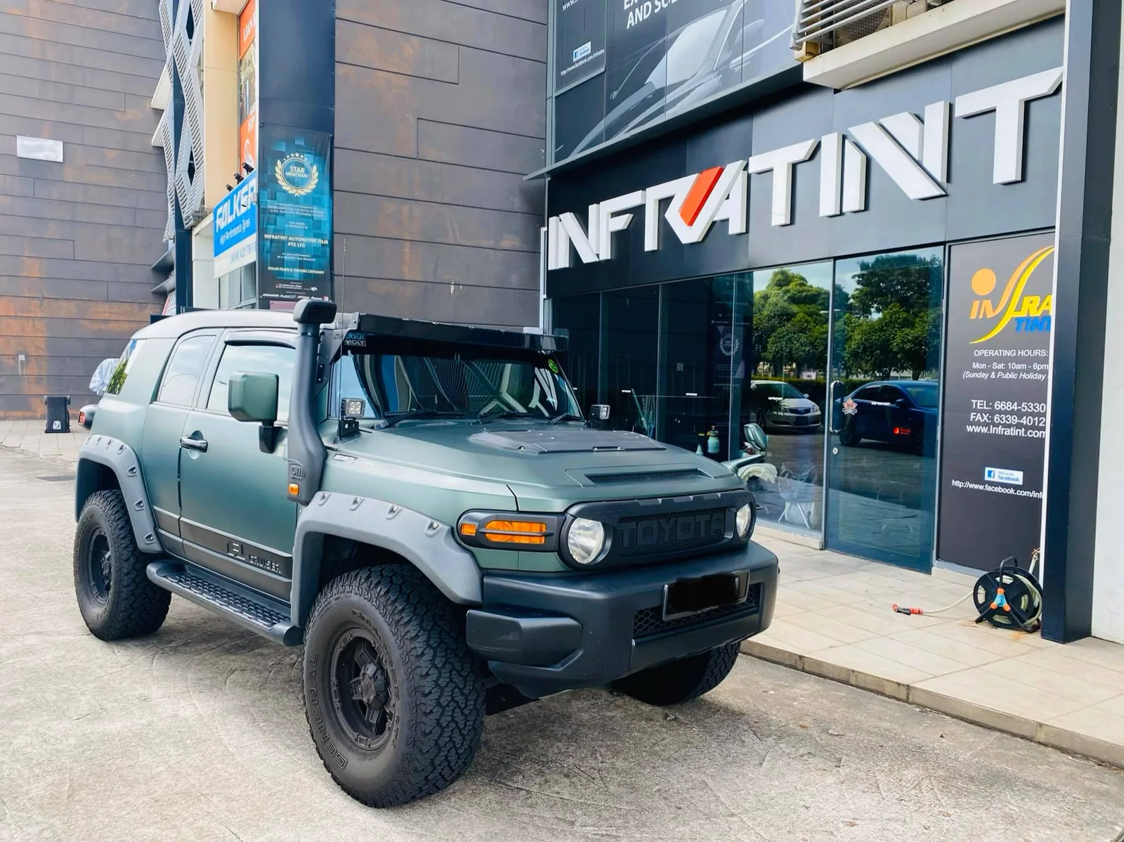 Green Toyota FJ Cruiser parked in front of the Infratint Singapore shopfront for window tinting