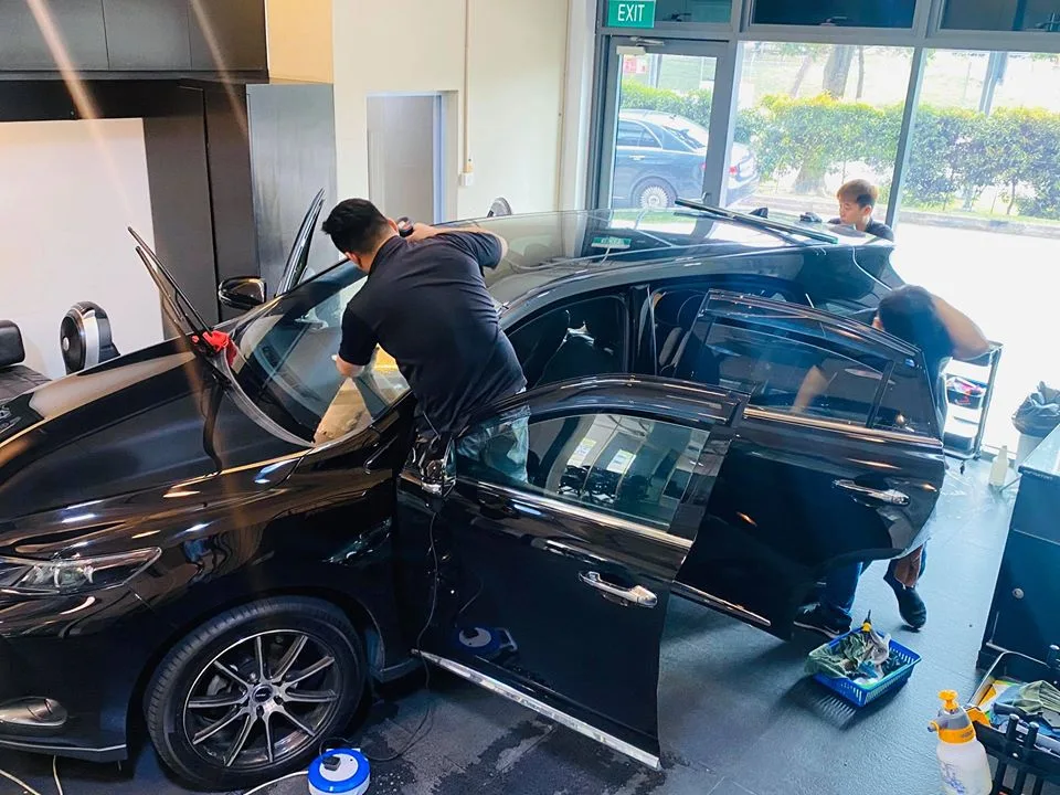 Black Toyota Harrier with doors open during window tint installation at Infratint Singapore