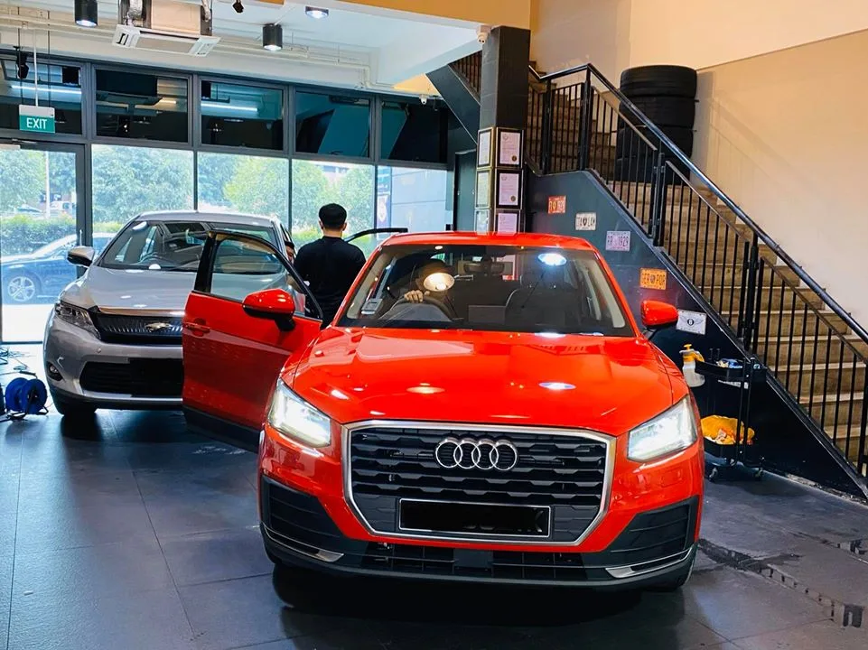 Red Audi Q2 and silver Toyota Harrier inside Infratint Singapore for window tinting