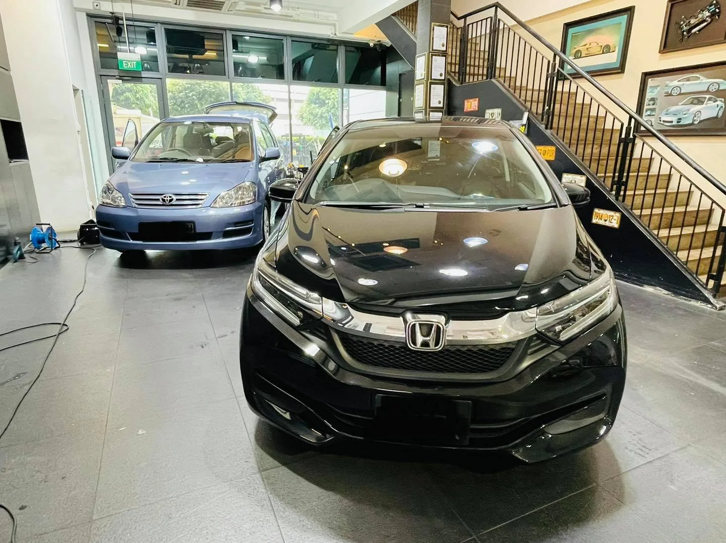Black Honda and light blue Toyota wagon inside Infratint Singapore for window film