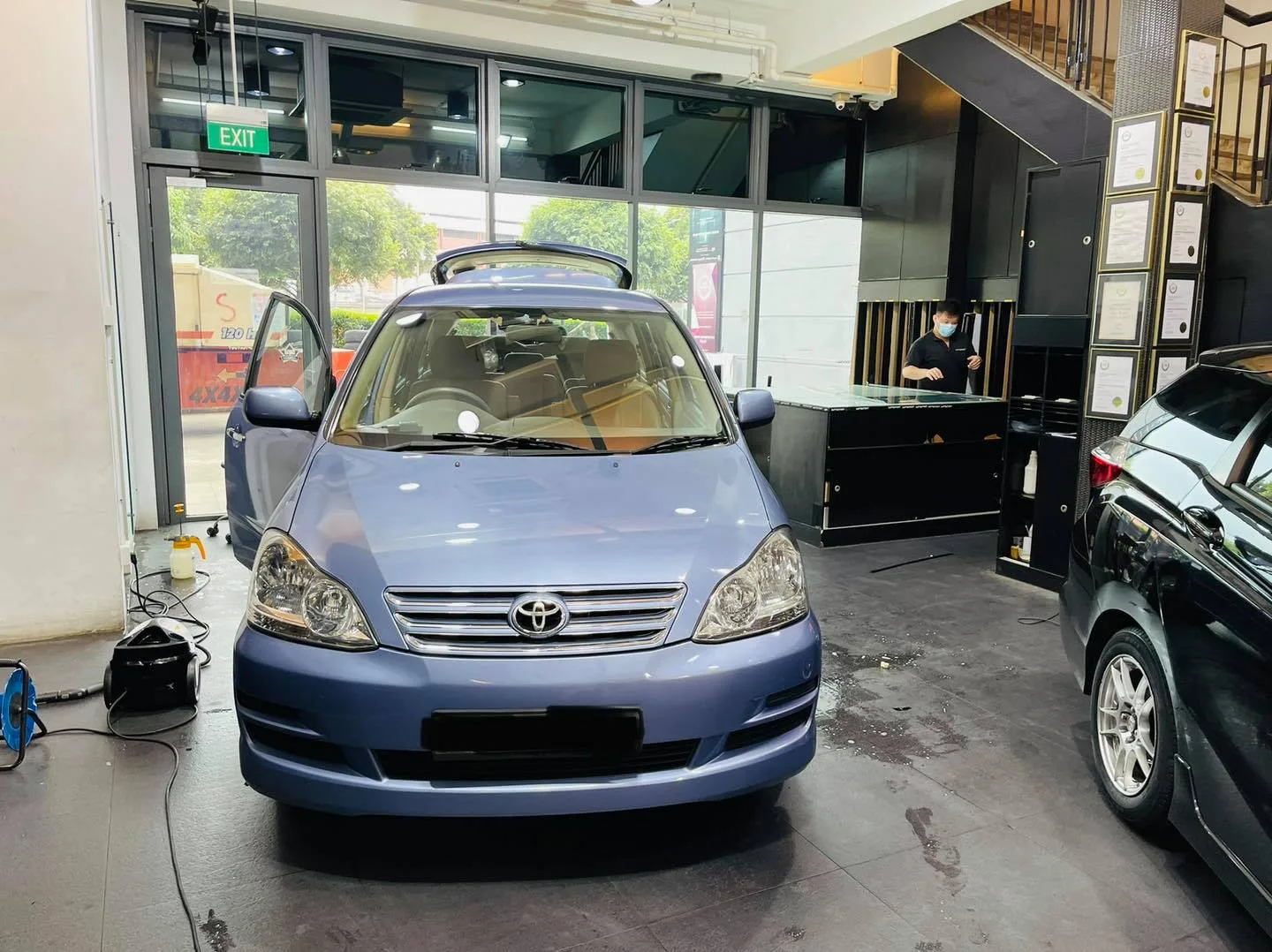 Light blue Toyota MPV viewed head-on at Infratint Singapore for window tinting