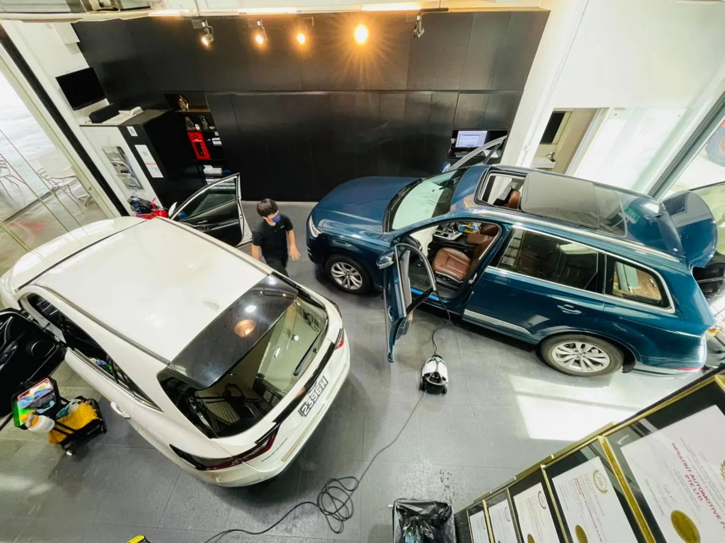 Overhead view of a white sedan and navy Audi Q7 at Infratint Singapore for window tinting