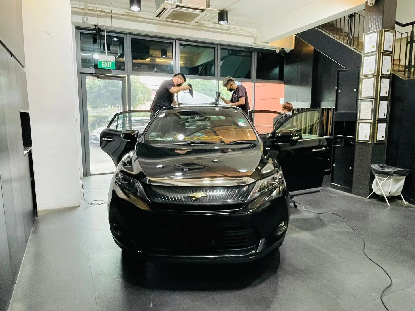 Black Toyota Harrier SUV having its windscreen tinted by two installers at Infratint Singapore