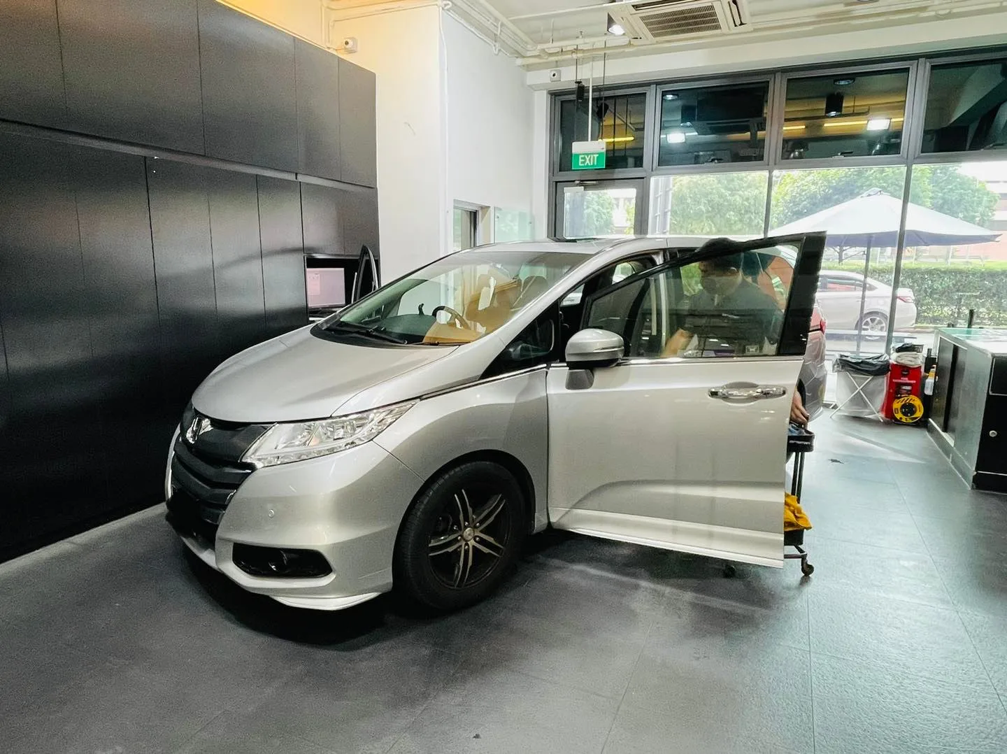 Silver Honda Odyssey MPV with sliding door open during window tinting at Infratint Singapore