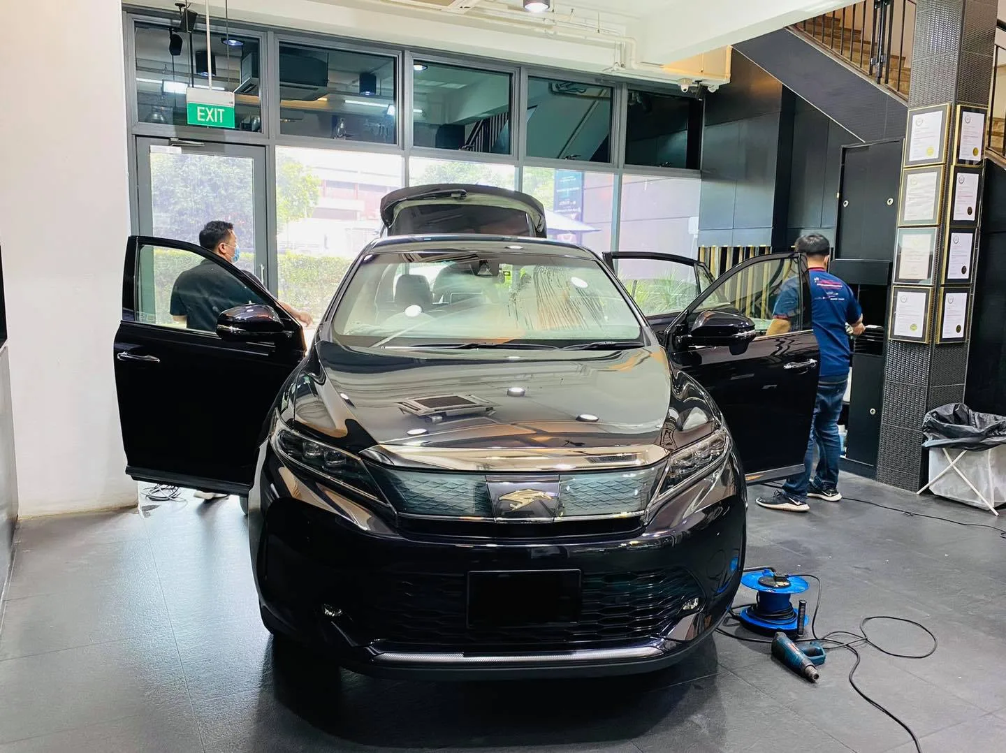 Black Toyota Harrier with doors open during window tinting at Infratint Singapore