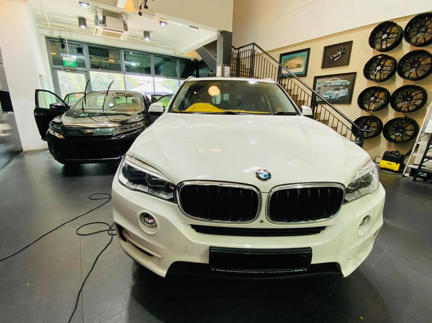 White BMW SUV and black Toyota Harrier inside the Infratint Singapore showroom