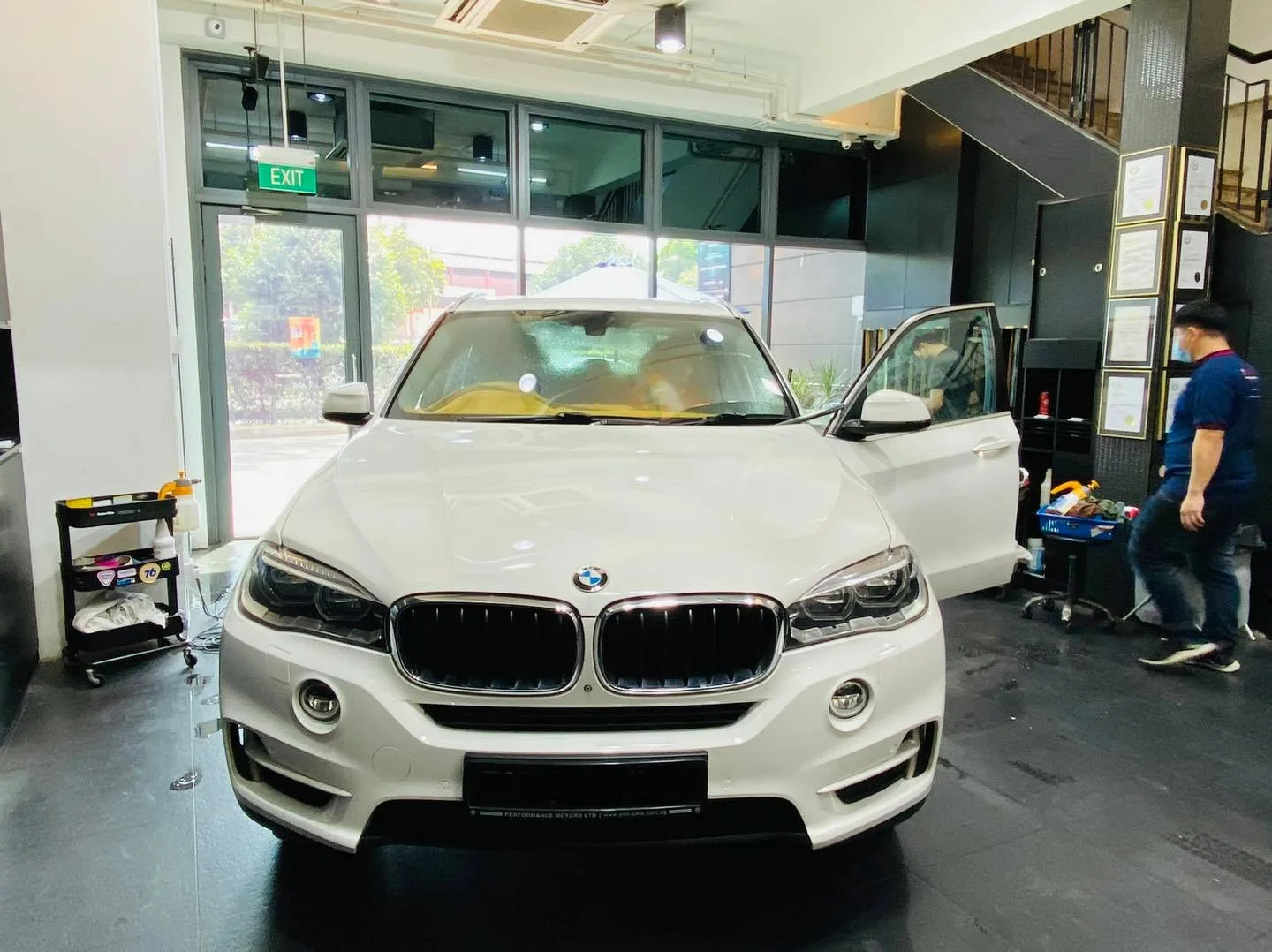 White BMW SUV front view inside the Infratint Singapore showroom for window tinting