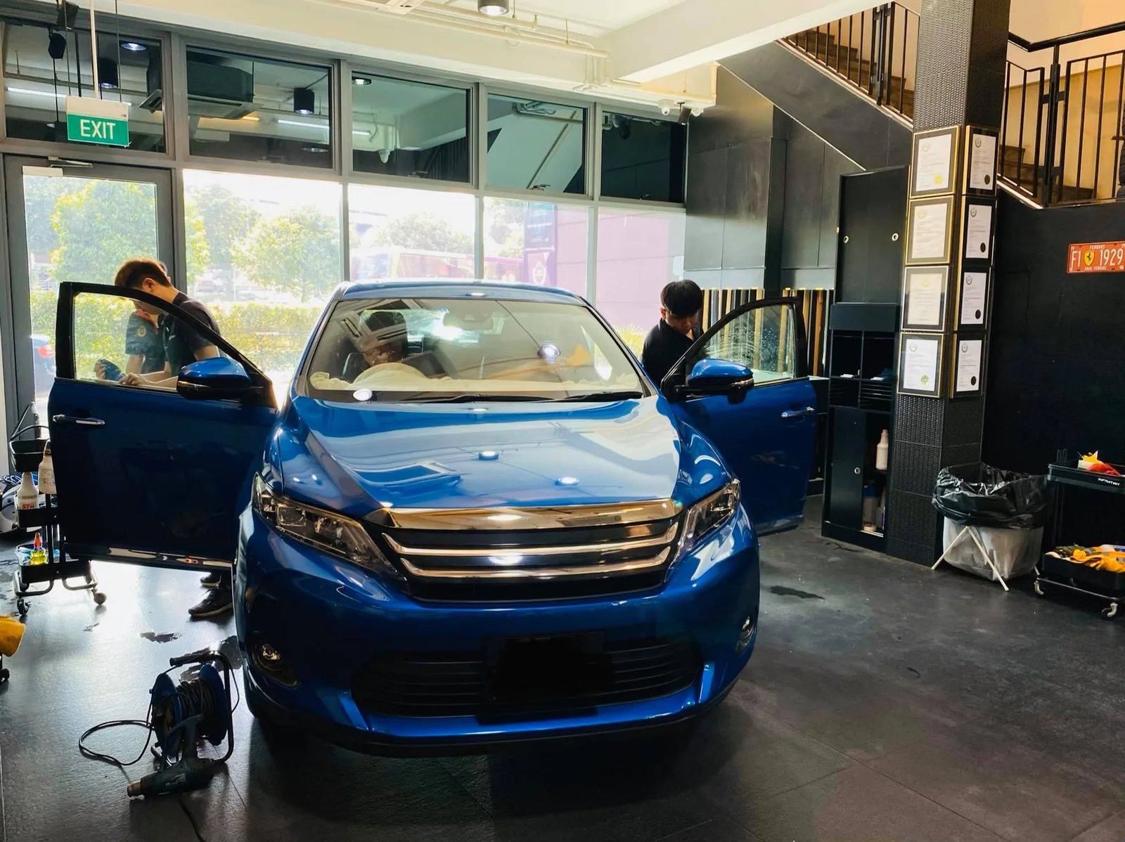 Blue Toyota Harrier SUV with doors open at the start of window tinting at Infratint Singapore