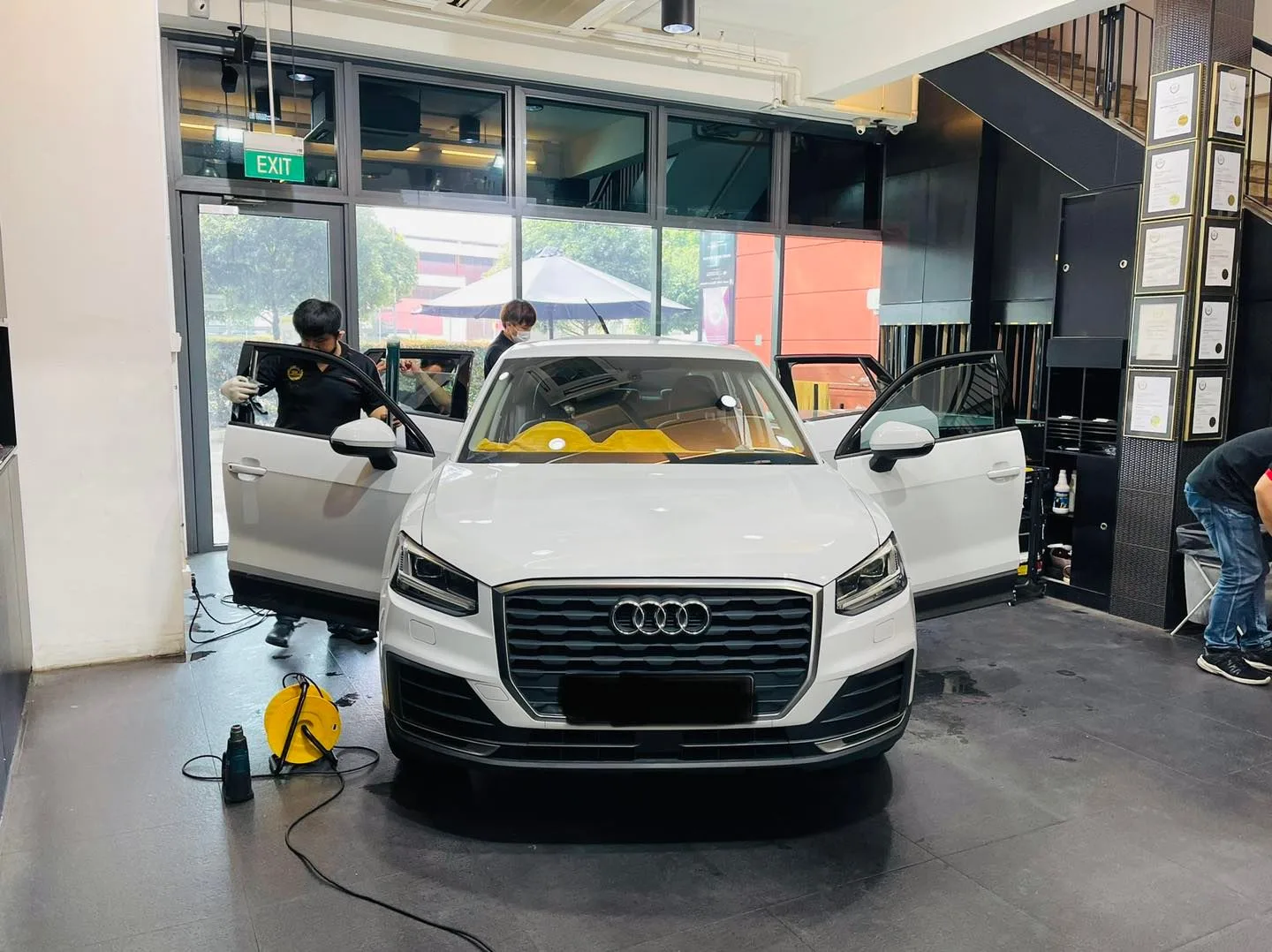 White Audi Q2 with doors open during window film installation at Infratint Singapore
